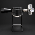 Cafetera espresso portátil negra con soporte y manómetro sobre fondo oscuro